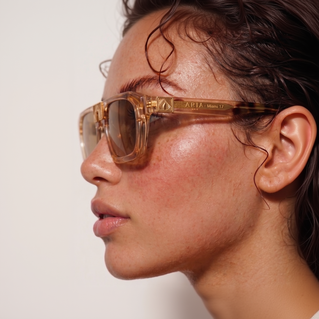 Close-up of a person wearing brown sunglasses with a blurred background