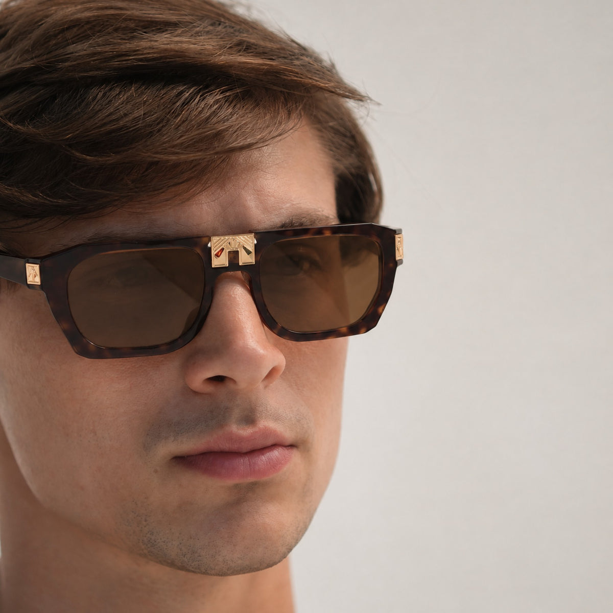 Model wearing ARIA NOIR Ahava sunglasses in Dark Tortoise acetate with gold bridge detail