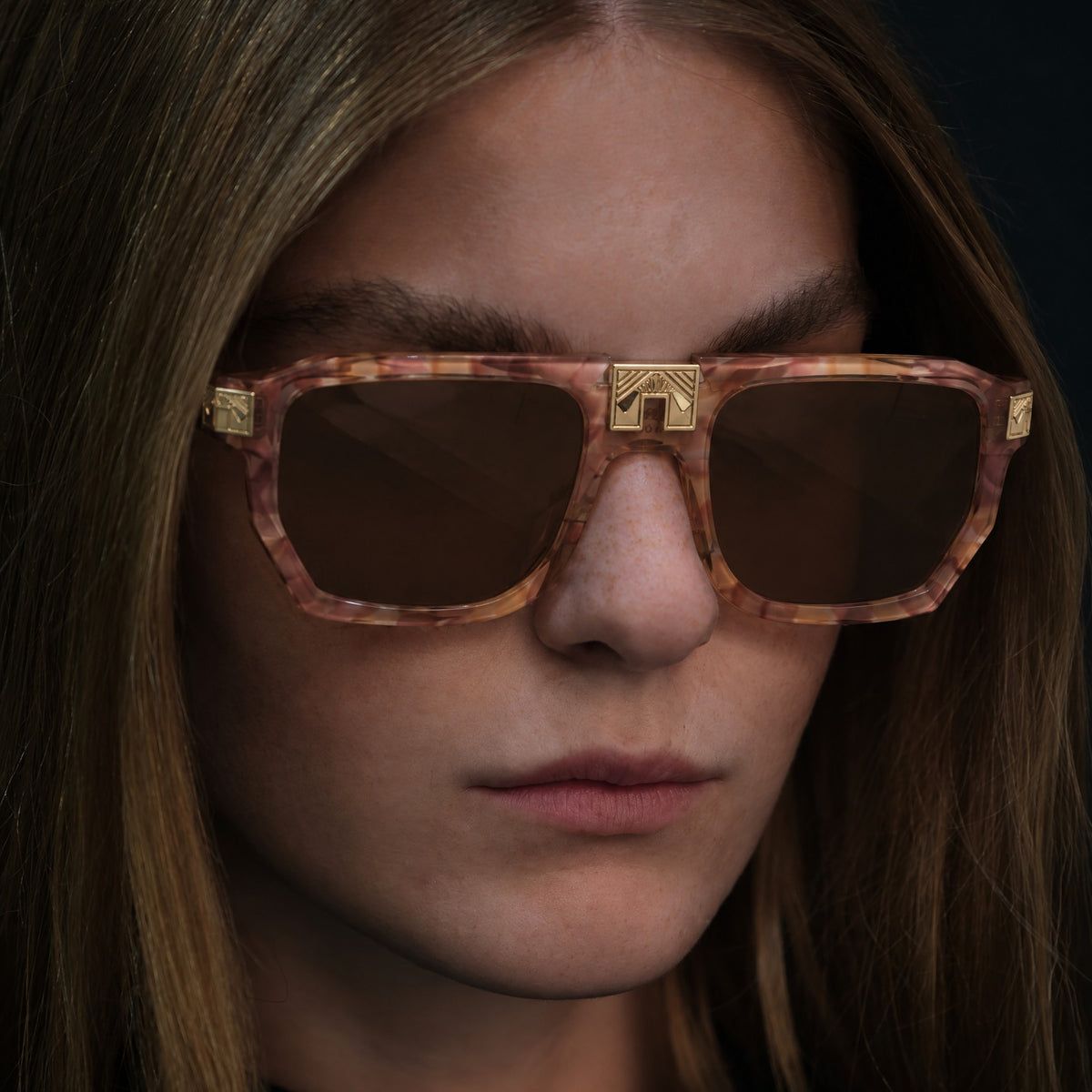 Model wearing ARIA NOIR ARCA II sunglasses in Dreamy Rose blush tortoise acetate with gold bridge detail
