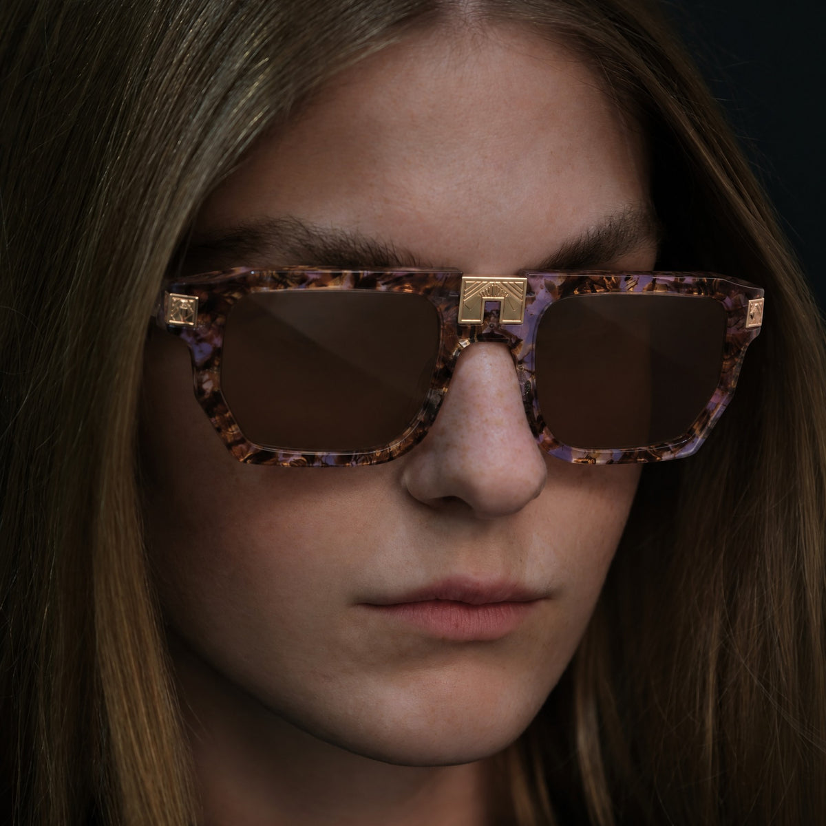 Model wearing ARIA NOIR ARCA II sunglasses in Pixie Dust lavender and brown tortoise acetate with gold bridge detail