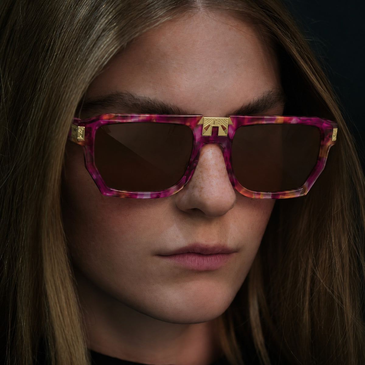 Model wearing ARIA NOIR ARCA II sunglasses in Tutti Frutti pink and magenta acetate with gold bridge detail
