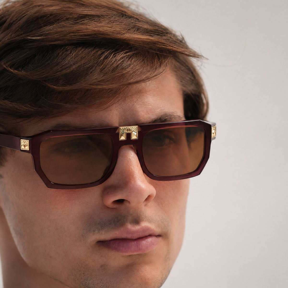 Model wearing ARIA NOIR ARCA II sunglasses in Velvet Rose burgundy acetate with gold bridge detail