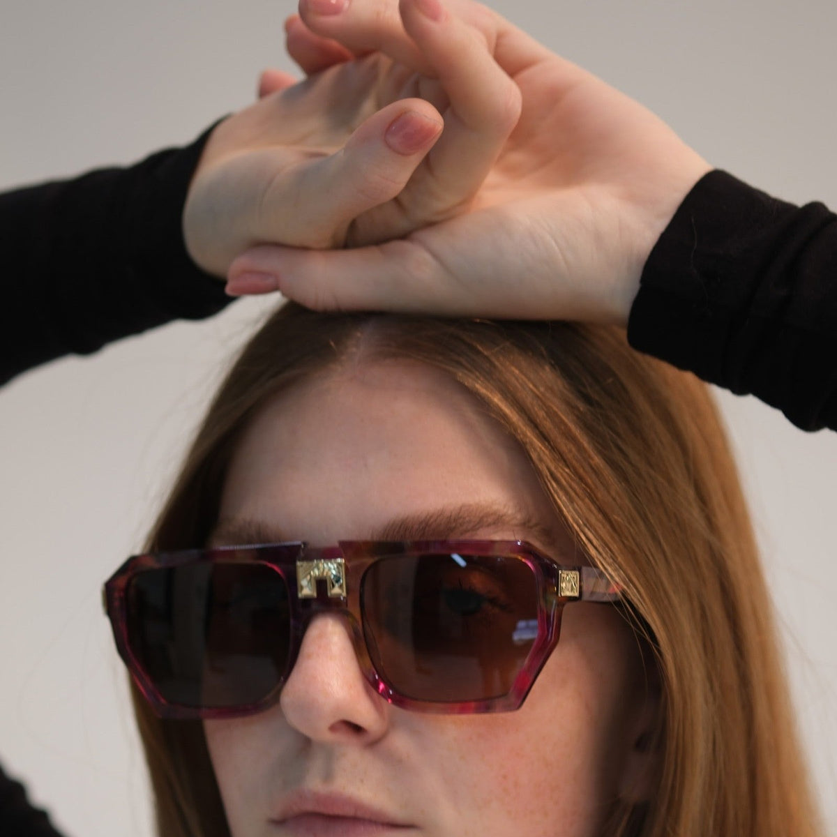 Model wearing ARIA NOIR Monarca sunglasses in Tutti Frutti pink and magenta acetate with gold bridge detail
