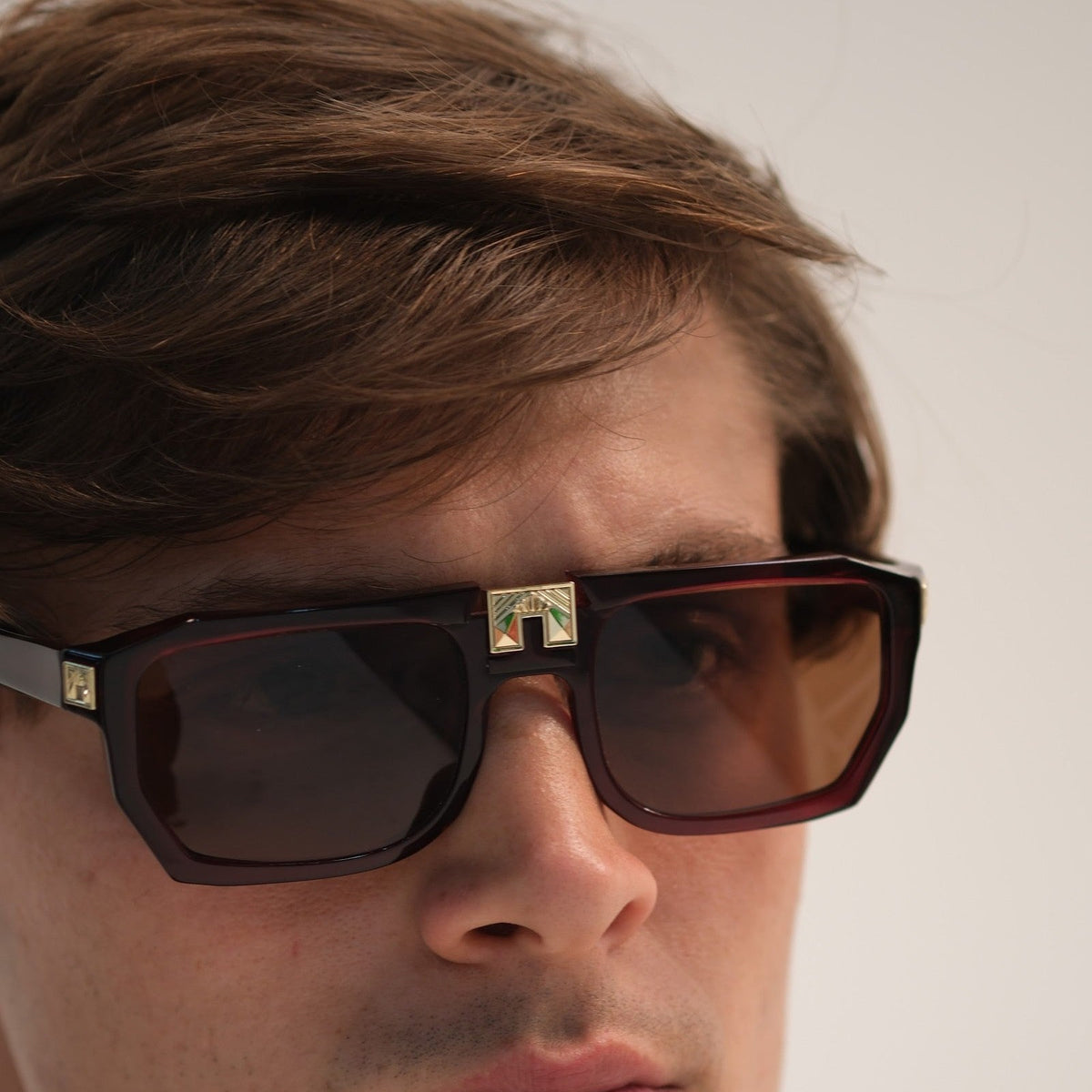 Model wearing ARIA NOIR Monarca sunglasses in Velvet Rose burgundy acetate with gold bridge detail